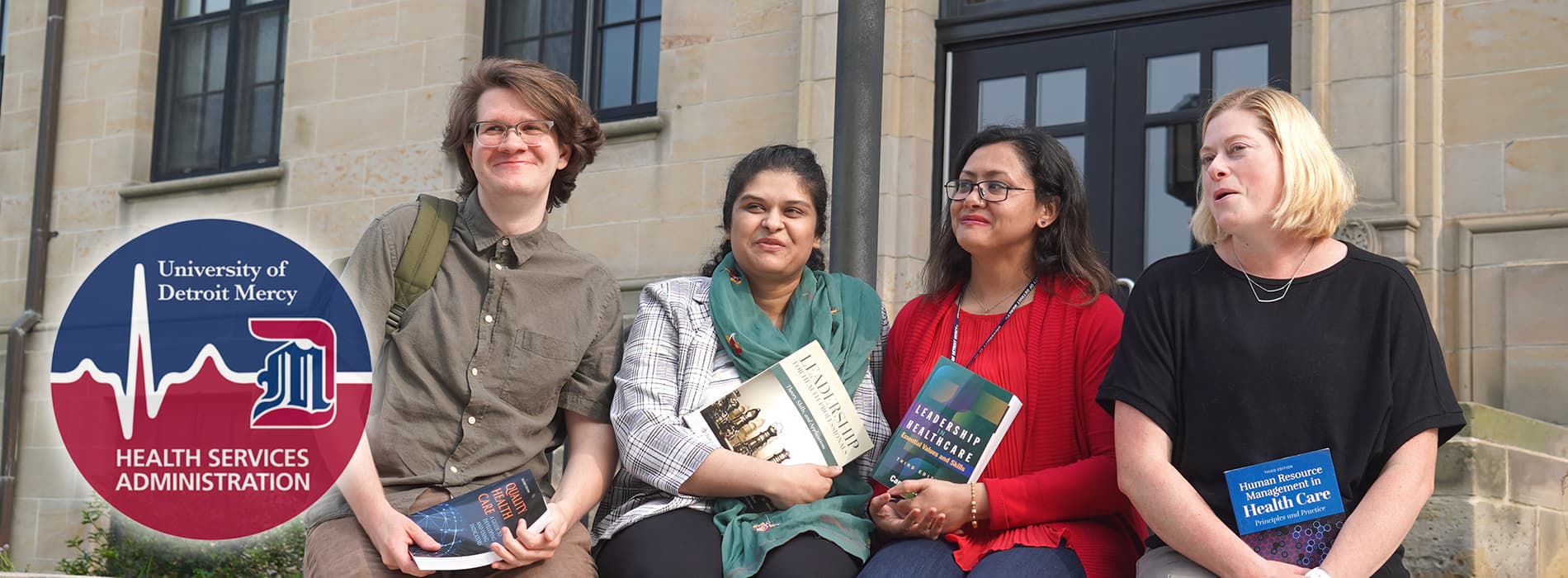 hsa grad students sitting outside holding books