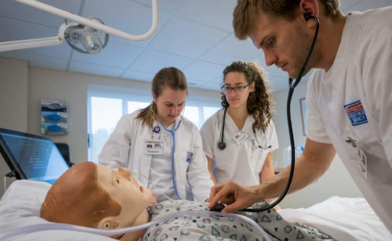 male nursing student check heart rate of sim manikin
