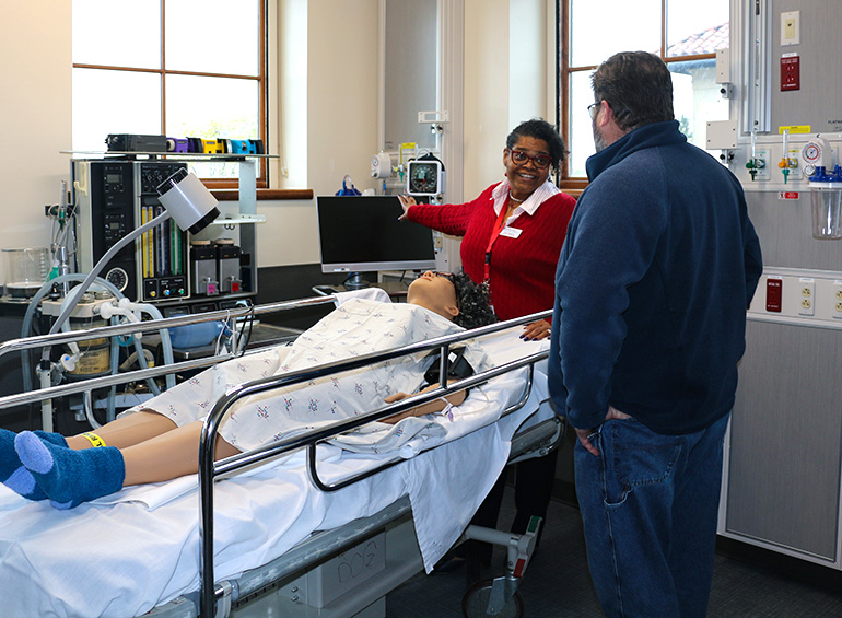 patient simulator with instructor giving a demonstration