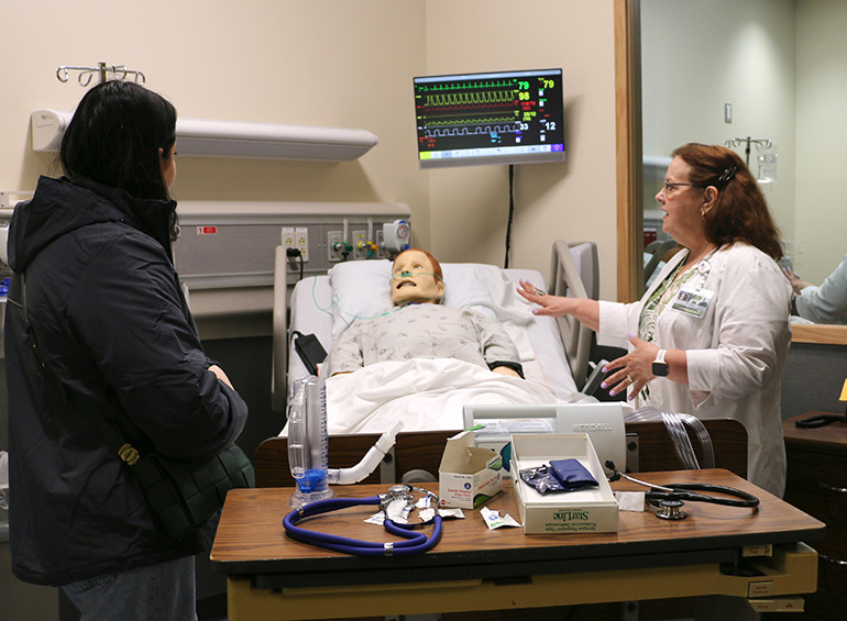 student and faculty in a simulation suite talking