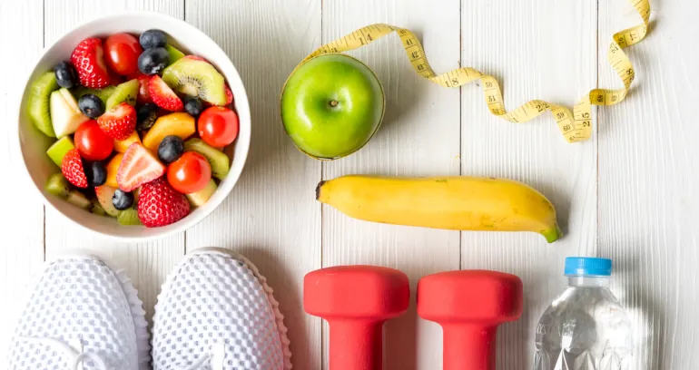 Healthy food choices, light exercise equipment, and a tape measure