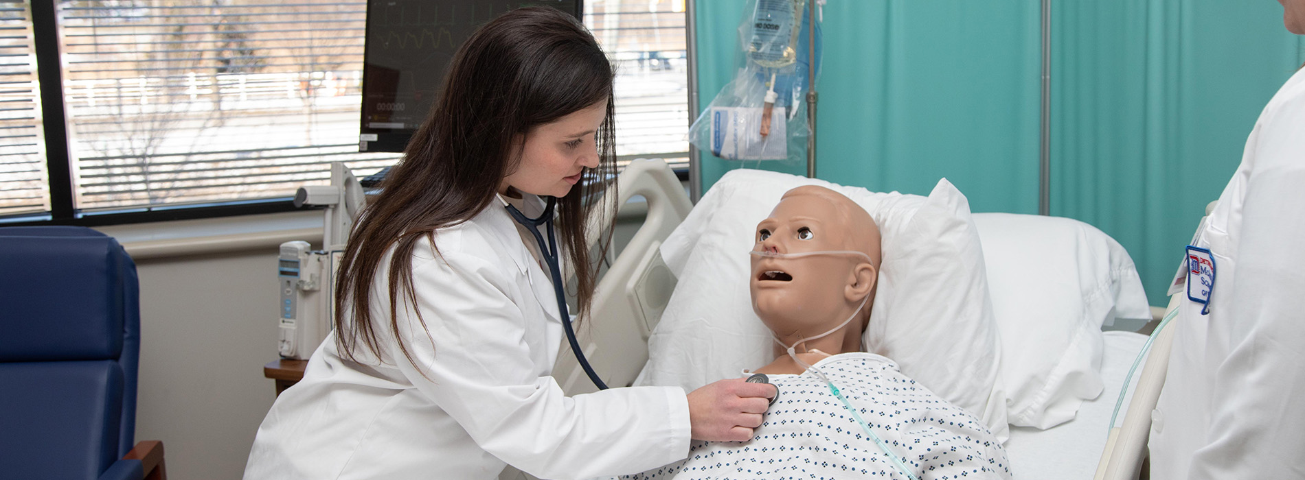 A MEAGN student practices healthcare with a manikin.