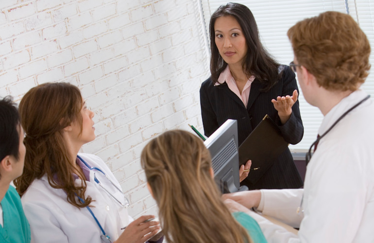 Hospital administrator talking with health care staff