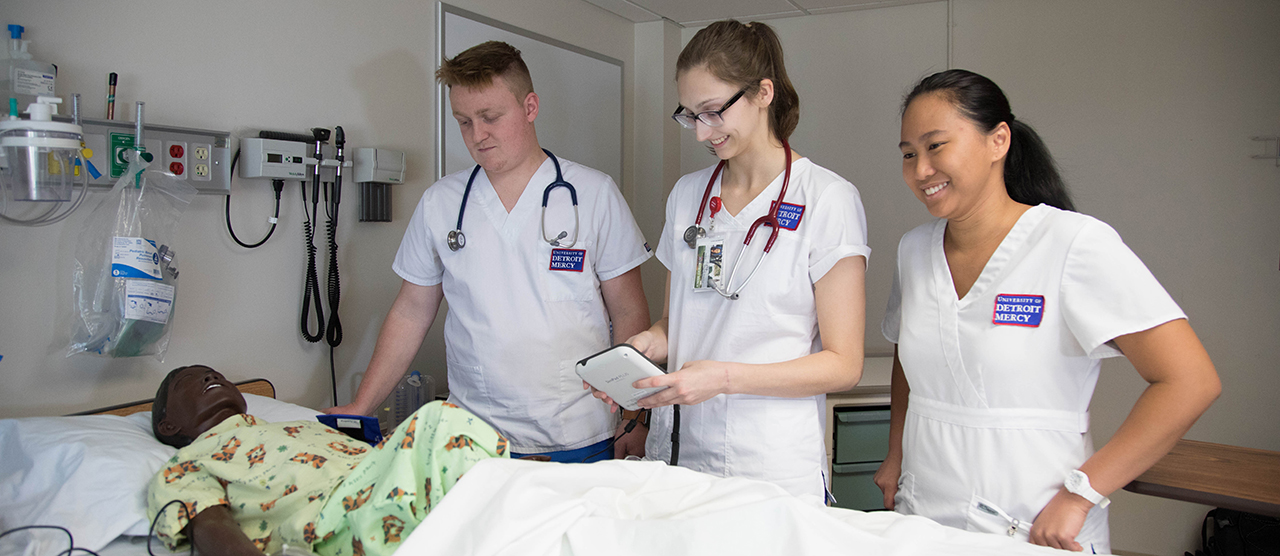 Nursing students work in a SIM lab.