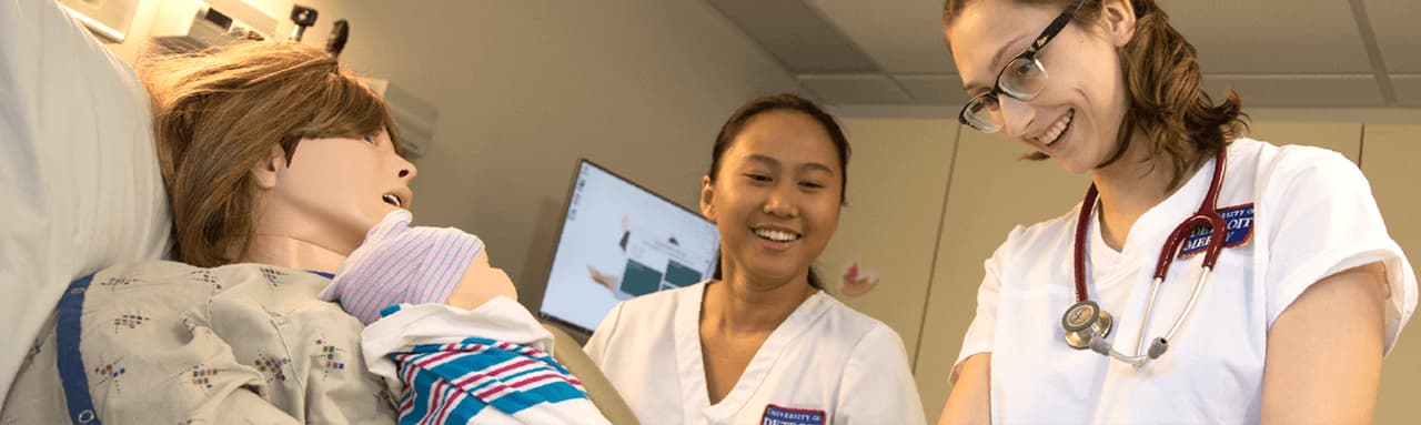 Nursing students work with a simulation dummy.