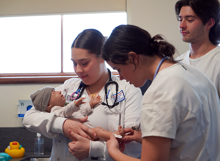 3 undergrad nursing students and the baby simulation manikin